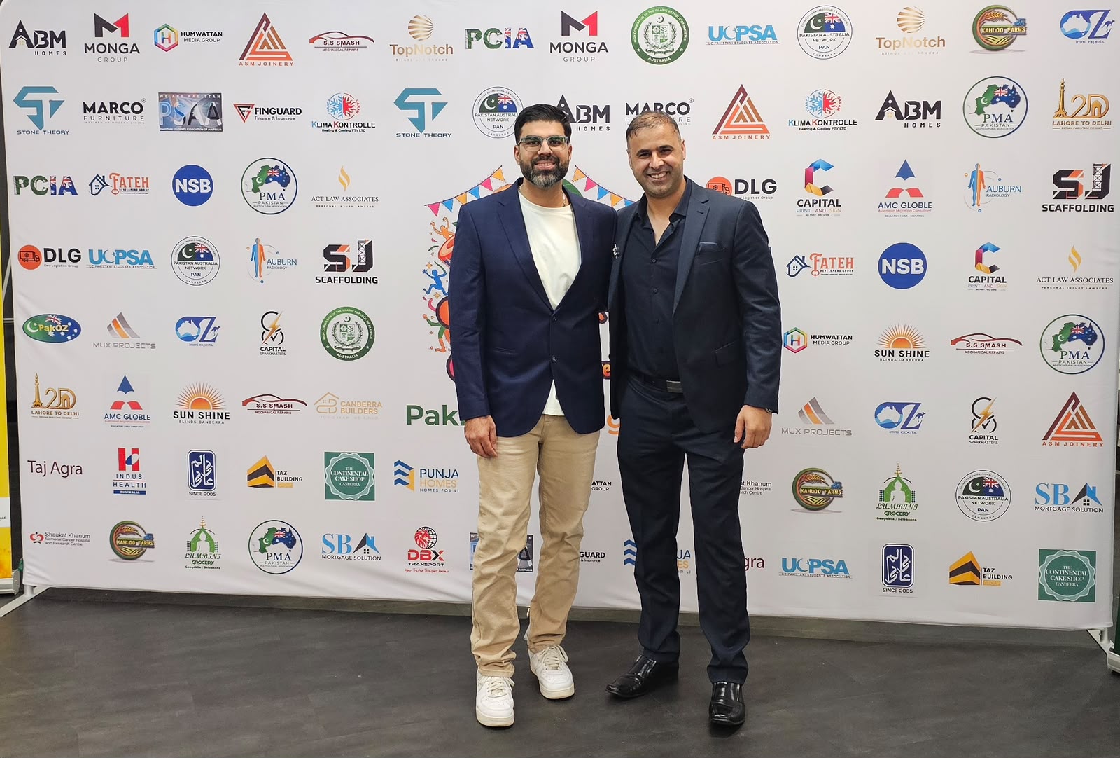 PMA members at the Mango Mela sponsor wall, Canberra