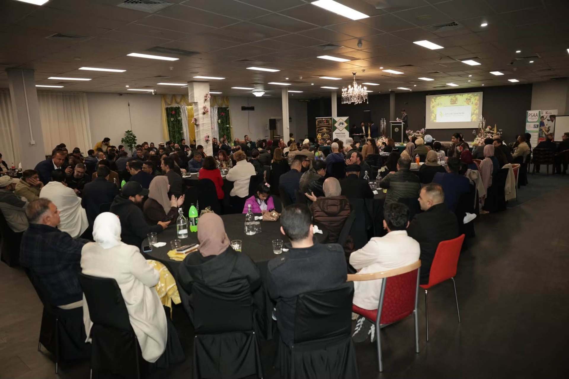 Community members gathered in the hall for the Mango Mela 2026 launch